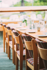 Cozy Interior Of Summer Cafe. Table And Cutlery Laid Out