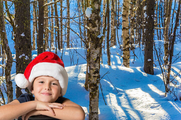 Boy in red Santa Claus hat smiling