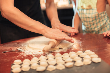 A man rolls out the dough for dumplings