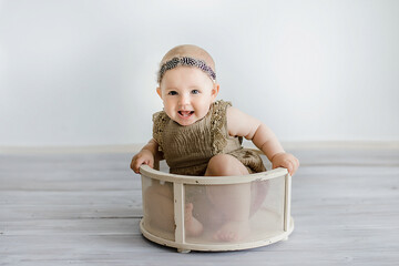 Portrait of cute Baby girl posing in a vintage basket.