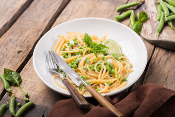 Italian pasta Cacio e Pepe - spaghetti with cheese and green pea