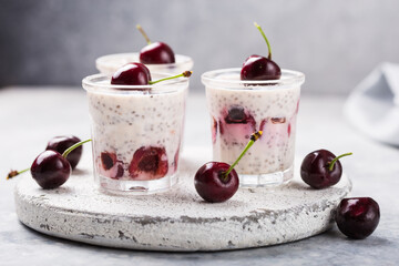 Chia pudding with cherry berries, natural yogurt,  in a glass on a grey surface. Selective focus. Healthy dessert, proper nutrition, super food.