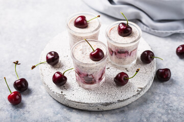 Chia pudding with cherry berries, natural yogurt,  in a glass on a grey surface. Selective focus. Healthy dessert, proper nutrition, super food.