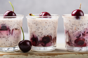 Chia pudding with cherry berries, natural yogurt,  in a glass on a grey surface. Selective focus. Healthy dessert, proper nutrition, super food.
