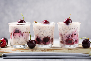 Chia pudding with cherry berries, natural yogurt,  in a glass on a grey surface. Selective focus. Healthy dessert, proper nutrition, super food.