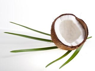 Coconut pieces with palm leaves isolated on a white background.