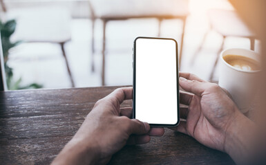 cell phone mockup image blank white screen.man hand holding texting using mobile on desk at coffee shop.background empty space for advertise.work people contact marketing business,technology