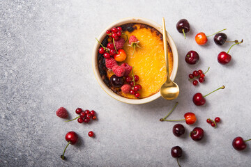 Creme brulee with raspberry  on light  baking sheet. Space for your caption.