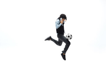 Fototapeta na wymiar Man in office clothes playing football or soccer with ball on white background like professional player. Unusual look for businessman in jump kicking ball. Sport, healthy lifestyle, creativity.