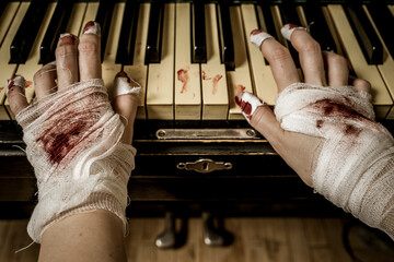 A bandaged bloody hands plays the piano