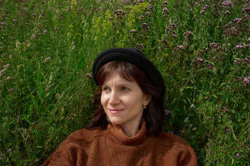 Portrait of adult female in hat sitting in meadow Karelia