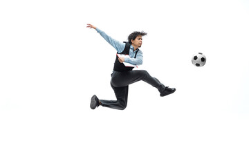 Fototapeta premium Man in office clothes playing football or soccer with ball on white background like professional player. Unusual look for businessman in jump kicking ball. Sport, healthy lifestyle, creativity.