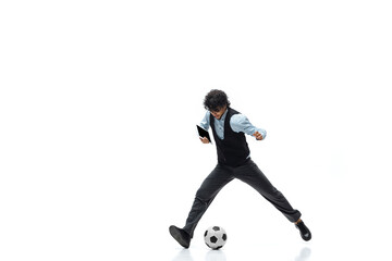 Obraz na płótnie Canvas Man in office clothes playing football or soccer with ball on white background like professional player. Unusual look for businessman in motion, action kicking ball. Sport, healthy lifestyle