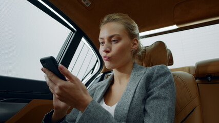 Portrait of serious business woman reading bad message in smartphone.