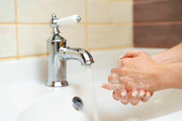 Woman washing her hands with soap close up