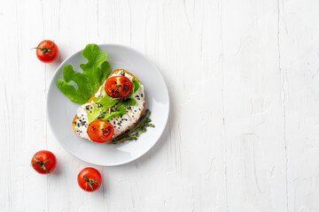 Sandwich with soft cheese and sliced tomatoes