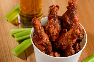 Portion of Buffalo chicken. Served with celery sticks and glass of light beer