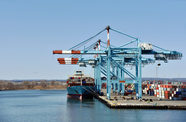 Newark, NJ / USA - View of the container terminal with berthed ship, gantry cranes are loading and...