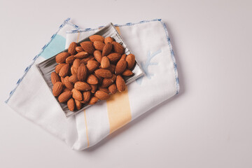Almond in a dish on a white background cloth. Top view