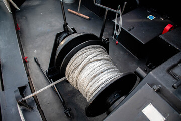 Kevlar rope on a winch in the stern of a black cruise ship