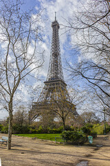Early spring in the park at Champ de Mars in Paris. In the background - famous Eiffel Tower. Paris, France.