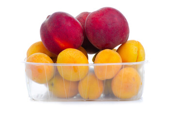 apricot and peach in plastic container on white background isolation