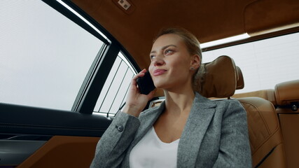 Fototapeta na wymiar Closeup relaxed businesswoman calling mobile phone in luxury car.