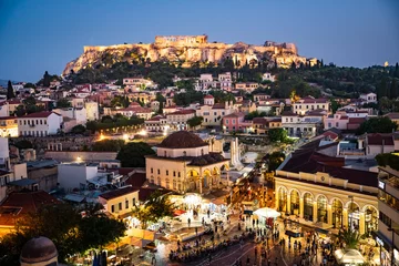 Poster The historical Acropolis in Athens Greece is enthroned above the lively old town Plaka with scenic lighting at night. © Anna