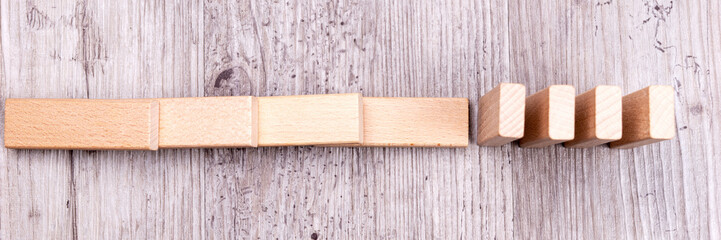 Domino effect. Wooden toy blocks on the ground