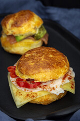 Assortment of homemade scones with ham, cheese, avocado, salmon, cream cheese and strawberry jam