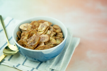 Homemade dehydrated banana chips cuisine fried in hot oil baked.