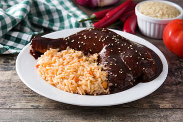 Traditional mole Poblano with rice in plate on wooden table