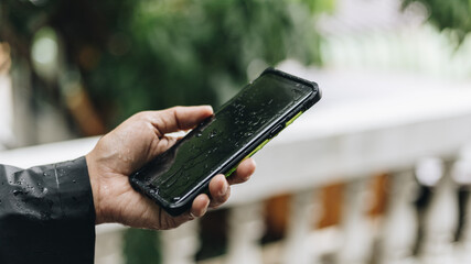 hands man using smartphone in the rain