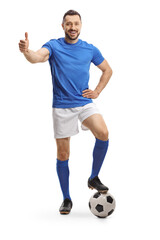 Soccer player in a blue jersey with his leg on a ball showing thumb up © Ljupco Smokovski