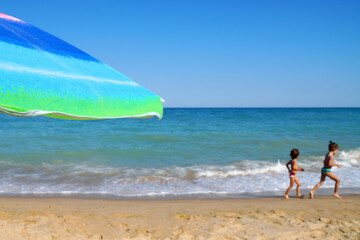 beach umbrella and sunglasses against the sea horizon and clear sky, copy space.