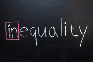 Obraz premium The word inequality on the blackboard.