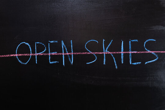 The concept of the abolition of The Treaty on Open Skies. OPen Skies text crossed out in red chalk on a chalkboard
