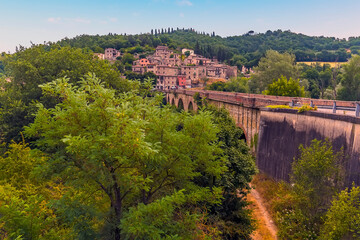 A view along the bridge over the River Tevere towards the village of  Pontecuti, Umbria, Italy in summer