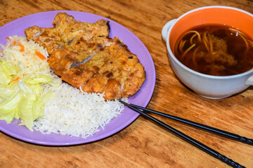 chop pork tonkatsu with cabbage and rice on a purple plate and miso noodle soup