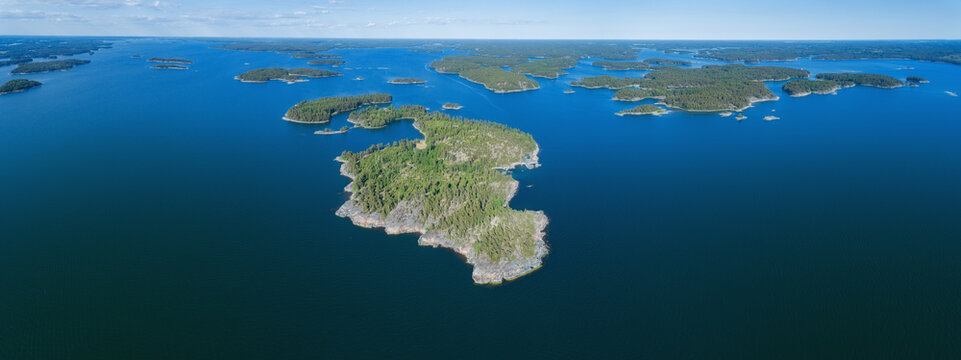 Aerial panoramic view of beautiful islands with forest in Baltic sea. Blue sky. Saaristomeri. Finland