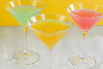 Several glasses of various delicious fruit non-alcoholic cocktails on a bright background. Health drinks