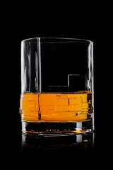 Scotch whiskey in crystal modern glass on black background.