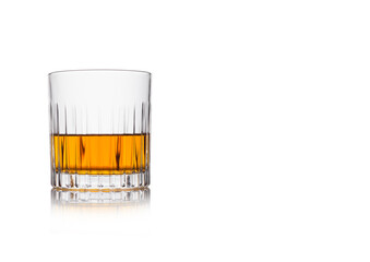 Scotch whiskey in crystal elegant glass on white background with reflection.