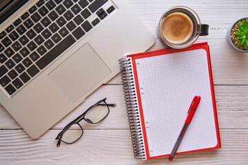 Wooden desk with laptop, notebook and coffee. Concept of study, work and business.