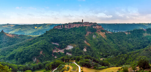 A panorama view towards the hill top settlement of Civita di Bagnoregio in Lazio, Italy in summer - obrazy, fototapety, plakaty