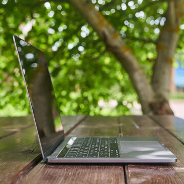 An open laptop stands on a wooden table. High-quality photo