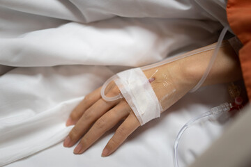 Close up hand of young peripheral venous catheter in the hand for Intravenous medication during lying in the hospital bed.  