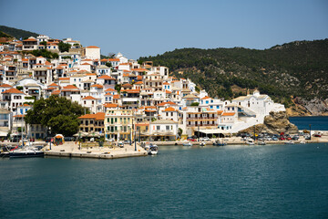 Fototapeta na wymiar The historical town on Skopelos island seen from the boat when entering the harbour in summer light.