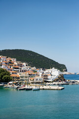 The historical town on Skopelos island seen from the boat when entering the harbour in summer light.