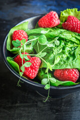 salad raspberries raw and lettuce spinach, arugula Menu concept serving size. food background top view copy space healthy eating